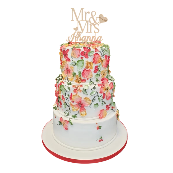 Three-tiered wedding cake with vibrant floral patterns and elegant sugar paste details.