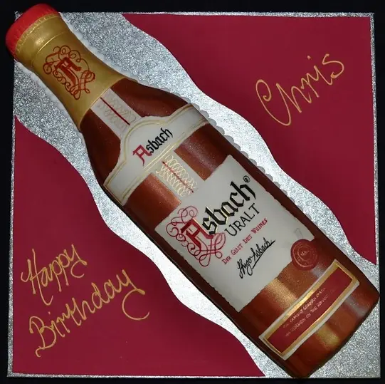 Bespoke cake shaped like an Asbach bottle with detailed label, crafted for celebration in Solihull, West Midlands.