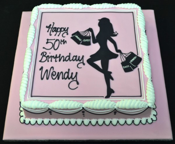 A beautifully decorated cake featuring a silhouette of a girl shopping, perfect for fashion-forward celebrations and events.