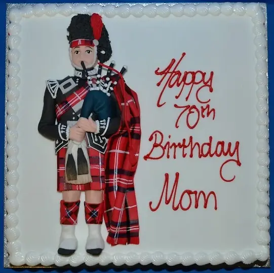 Bespoke cake shaped like a bag piper with detailed tartan outfit, displayed in Solihull, West Midlands celebration.