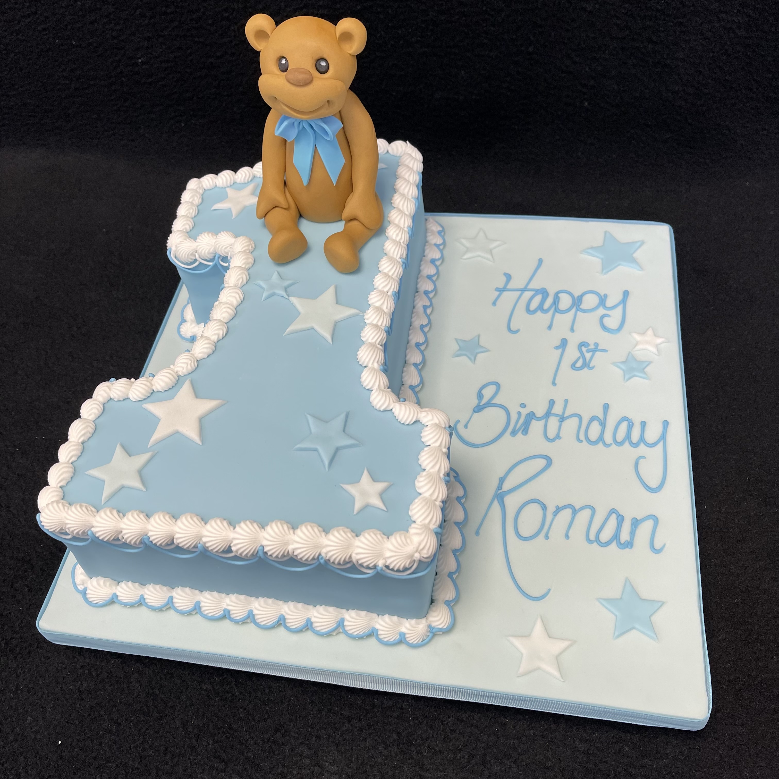 Adorable teddy bear themed number 1 cake for a special celebration, featuring a cute teddy bear decoration on the top of the cake. Perfect for a first birthday!