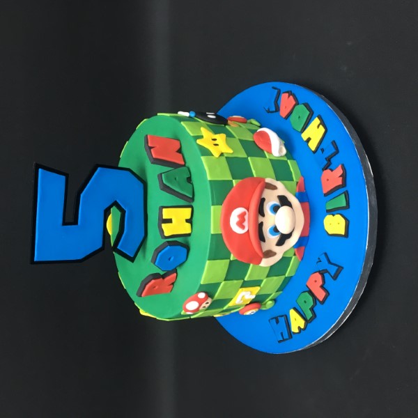 Bespoke Mario-themed cake with vibrant red, blue, and yellow icing, crafted for celebration in Solihull, West Midlands.