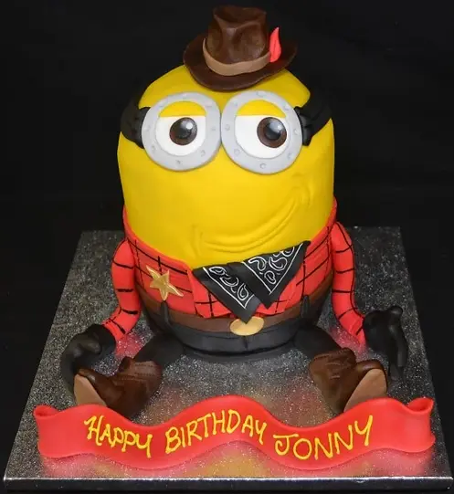 Bespoke cowboy Minion cake with fondant hat and boots, crafted for celebration in Solihull, West Midlands.