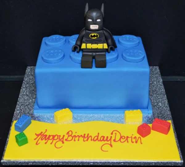 A creative and vibrant Batman-themed cake featuring a Lego brick design, perfect for superhero fans and themed parties.