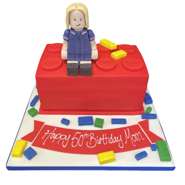 Bespoke Lego brick cake topped with a nurse figure, crafted for celebration in Solihull, West Midlands.