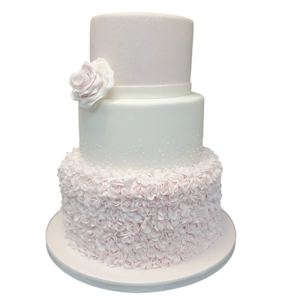 Three-tiered wedding cake with sugar paste flowers and pastel ruffles.