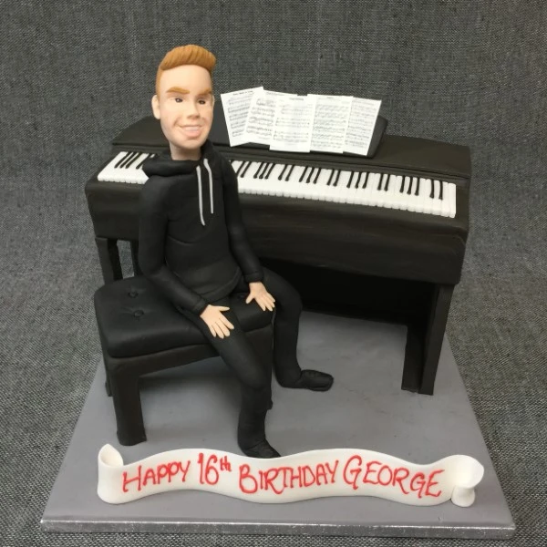 Bespoke Piano Man cake with black and white keys and musical notes, crafted in Solihull, West Midlands.