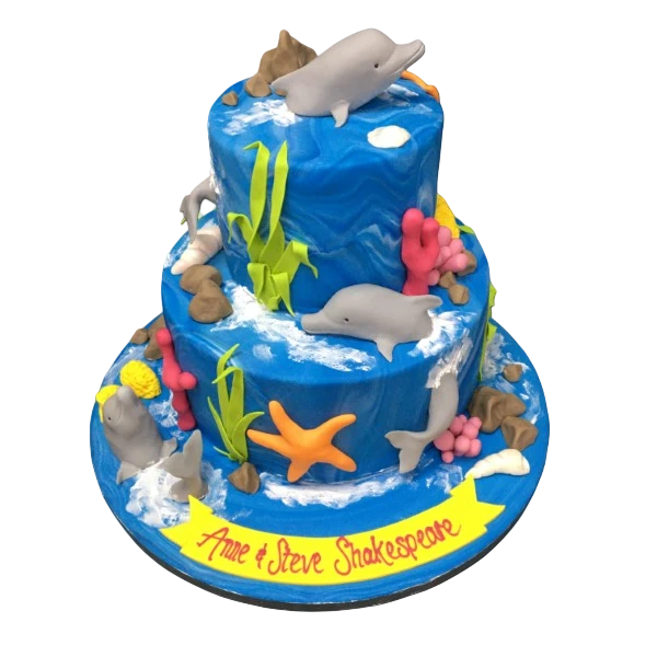 Bespoke under the sea celebration cake with dolphins and ocean details in Solihull, West Midlands.