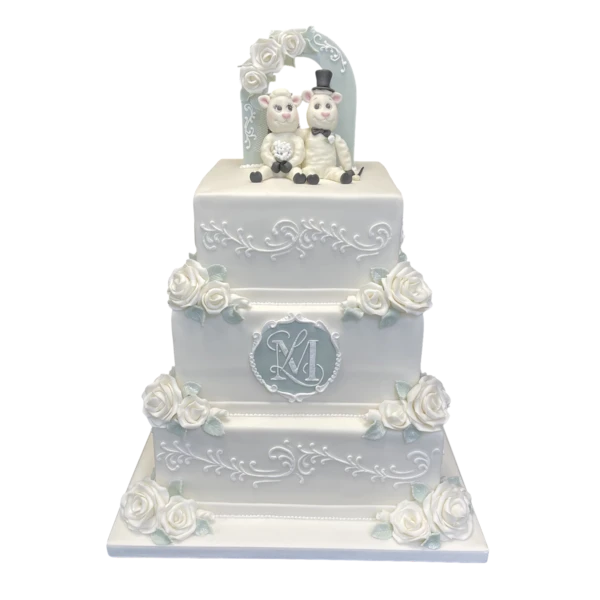 Three-tier luxury wedding cake with white sugar paste roses and elegant scrollwork.