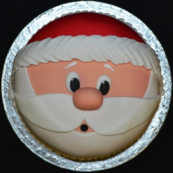 Festive Santa Claus themed Christmas cake with red and white decorations and a jolly holiday design perfect for seasonal celebrations and gatherings.