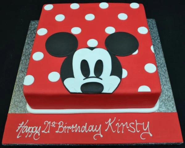 Mickey Mouse themed cake with a unique design featuring the character poking his head out with spots in a square shape. Perfect for Disney fans' celebrations.
