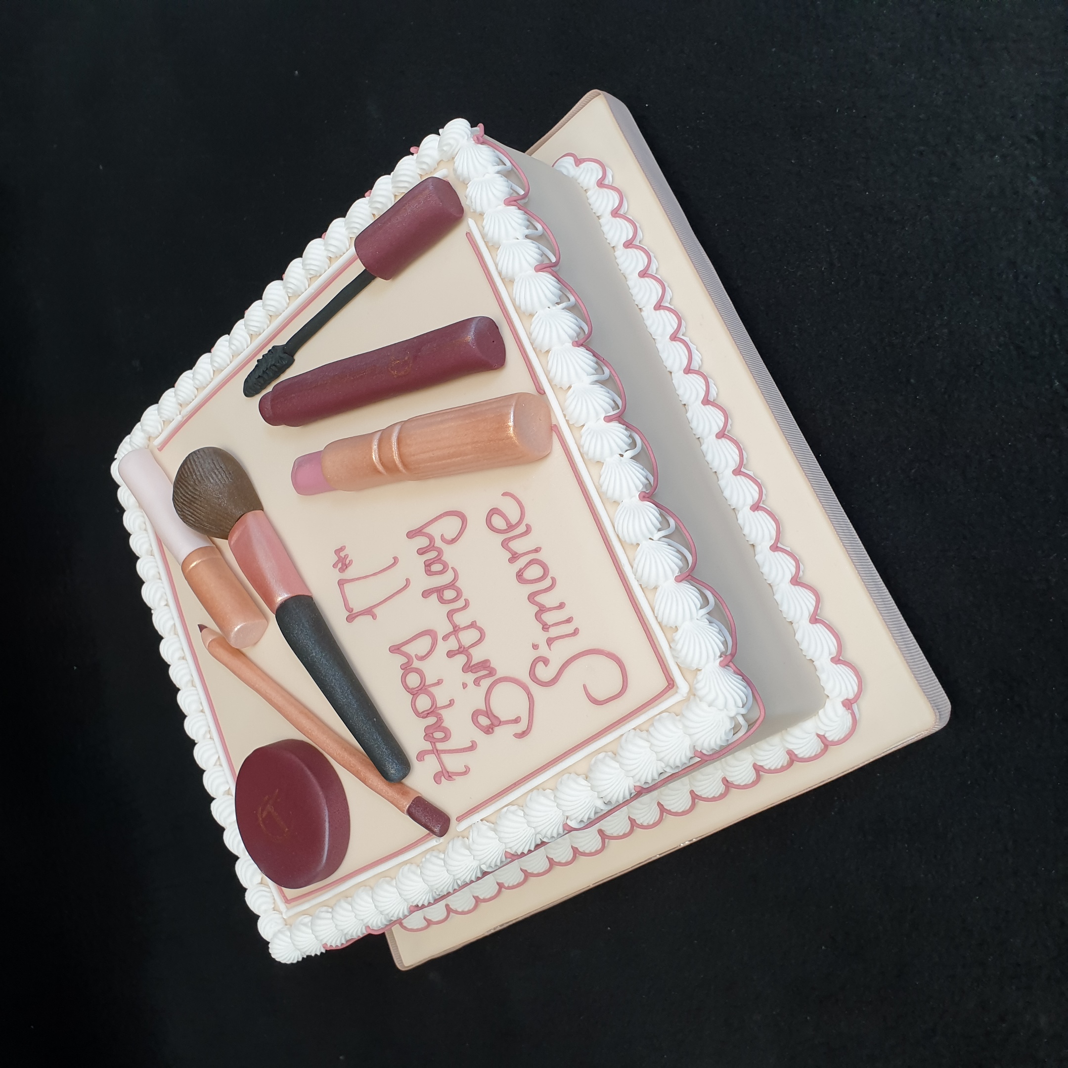 Bespoke makeup-themed cake with edible lipstick and brushes, crafted for celebration in Solihull, West Midlands.