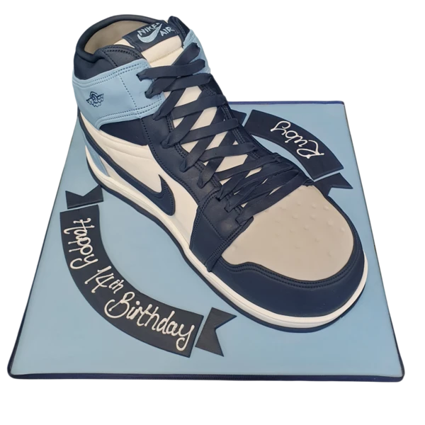 Bespoke cake shaped like a Nike Air Jordan high top trainer, detailed with red, black, and white icing in Solihull, West Midlands.