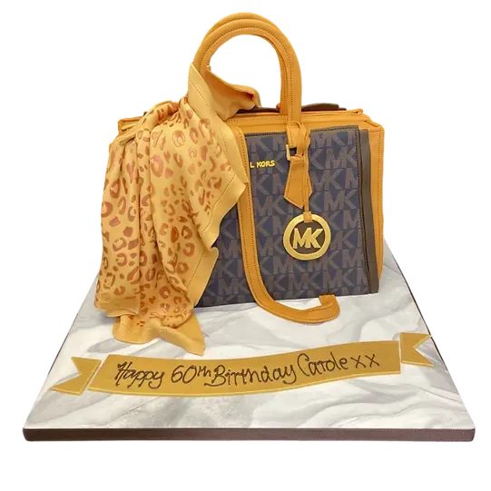 Bespoke cake shaped like a Michael Kors handbag with gold accents, crafted for celebration in Solihull, West Midlands.