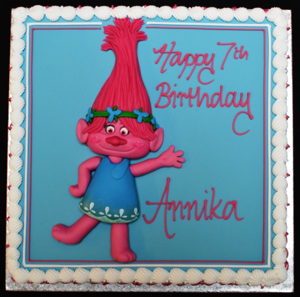 Bespoke cake featuring a colorful Poppy Troll figure with vibrant hair, set on a celebration base in Solihull, West Midlands.