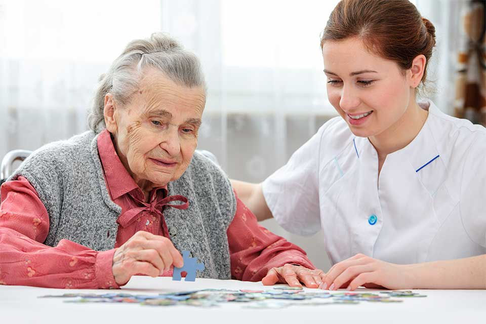 Senior doing a puzzle at a memory care facility.