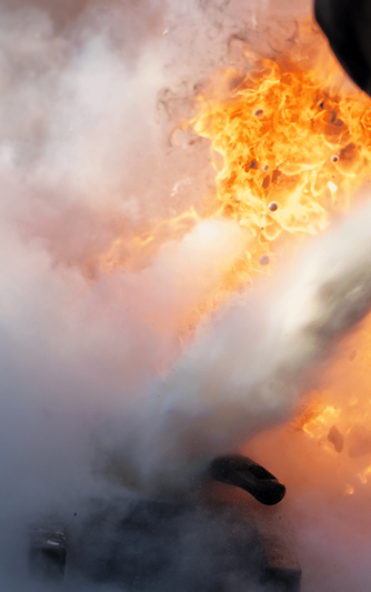 Staff member operating a fire extinguisher under expert ex-fire officer guidance