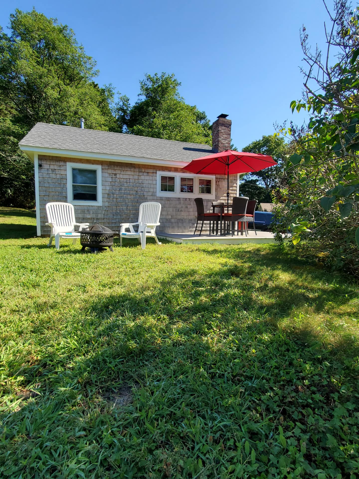 Outdoor seating and yard beside Ladybug Cottage in Plymouth.