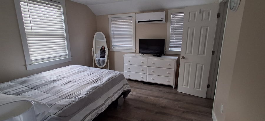 Queen bed and TV inside the Ladybug Bungalow studio.