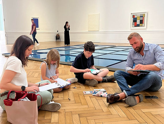 Family with two children drawing during a family-friendly Art Lab Tour experience in a museum in Rome