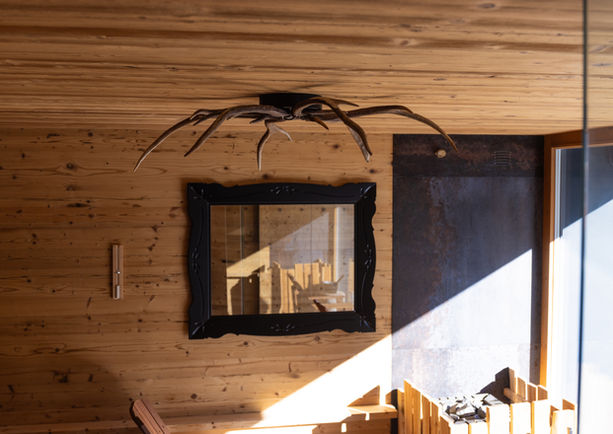 lampadario Aranea in corna di cervo installato in sauna in legno dal design wellness
