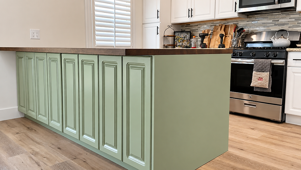 Sage green kitchen island with raised-panel cabinet doors, dark countertop and wood-look flooring