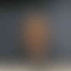 garota vestindo minissaia plissada de couro caramelo, suéter marrom, bolsa pequena, bota de cowboy western preta com estampa branca e óculos escuros