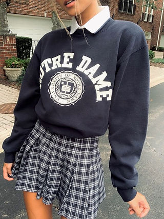 garota vestindo minissaia plissada xadrez, moletom estilo colegial azul marinho e branco