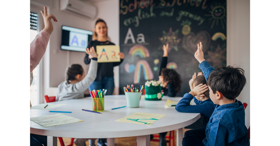 Teacher teaching alphabet to children in classroom