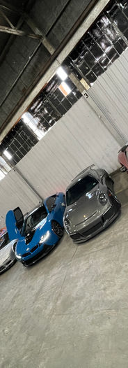 Ferrari and BMW and lamborghini and mclaren cars set up for shoot for music video