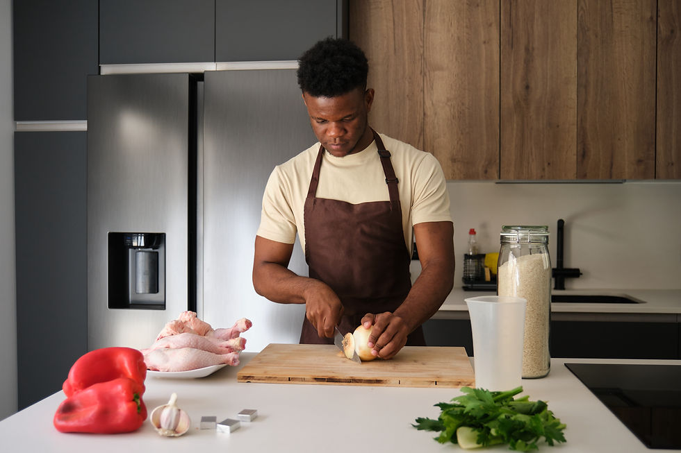Haitian man cutting onions in the kitchen preparing to cook