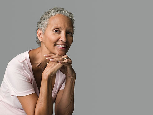 elderly-woman-smiling-gently-against-a-grey-backgr-2024-06-05-20-06-22-utc.jpg