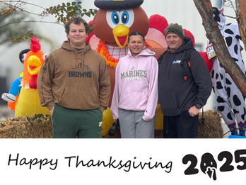 Three people pose with Happy Thanksgiving 2025 celebration, and a turkey.