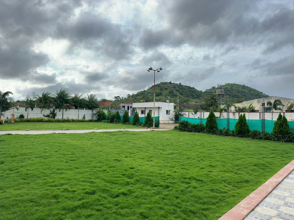 Wide-angle view of a family-friendly lawn near a peaceful homestay in Junnar.