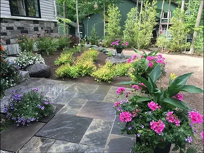 Custom cottage softscape garden with stone patio, colorful flowers, and landscape design