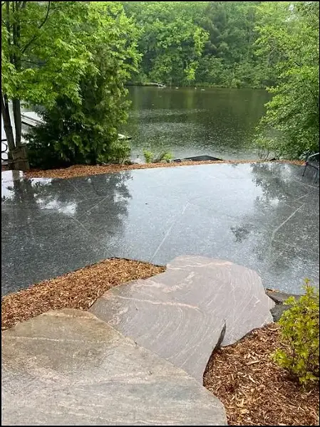 Custom granite patio overlooking waterfront cottage landscape in Muskoka