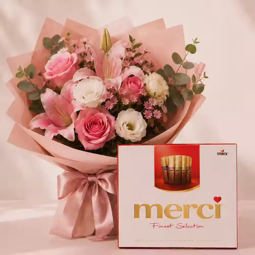 Premium bouquet with roses, lilies, seasonal flowers, greenery, and Merci chocolates.
