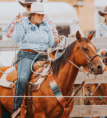 Bar M Founder, Millie, ready to make a roping run at a rodeo wearing a custom hat