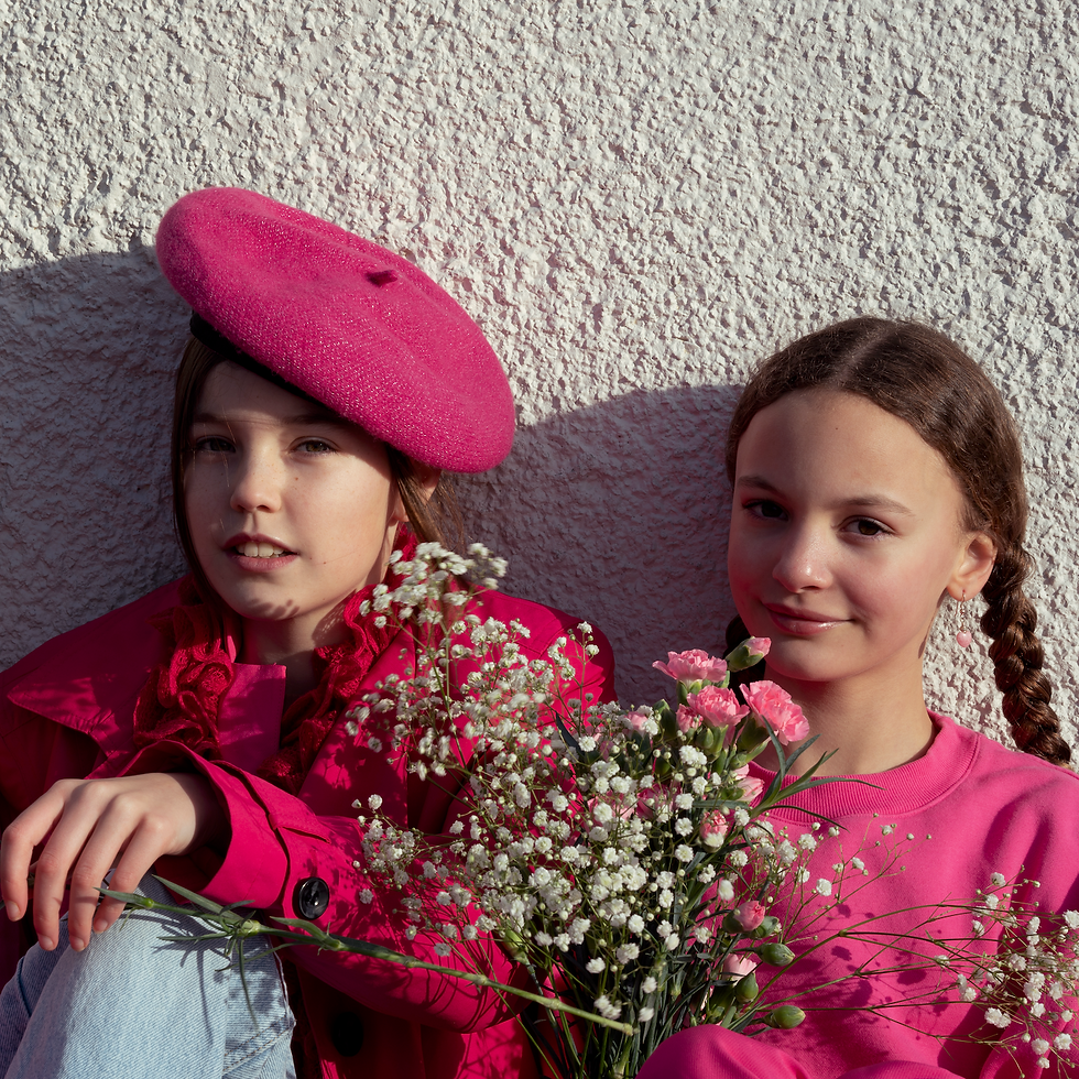 Two girls dressed in pink holding flowers