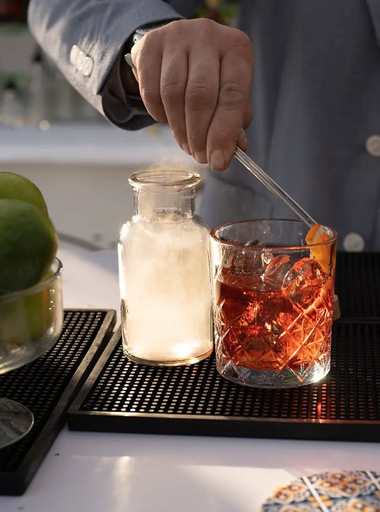 Barman professionista prepara un Negroni artigianale durante un evento firmato Mamu Soul Beverage