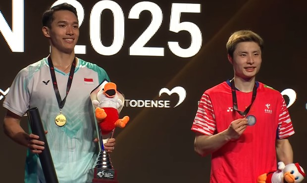 Jonatan Christie hoisting the Denmark Open 2025 trophy after his victory.