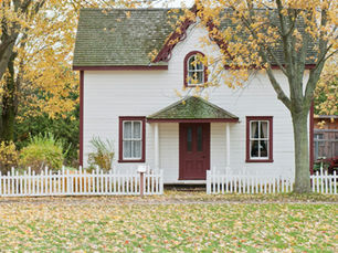 Casa con letrero de 'se vende' frente a ella, ilustrando el riesgo de confiar en un ARV mal calculado para un fix & flip