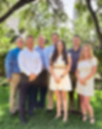 Group of seven Pitisci professionals pose for a photo in front of downtown Tampa .