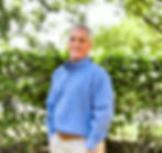 Smiling Chris Pitisci in blue shirt stands outside; Pitisci & Associates