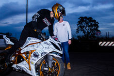 a man standing next to a motorcycle with a helmet on