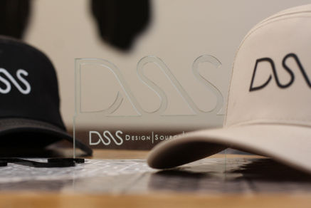 a hat sits on a table in front of a sign that says dss design source