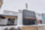 Exterior photo of a modern building with a smokestack that has the numbers 132