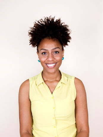 Black woman in yellow shirt smiling and happy