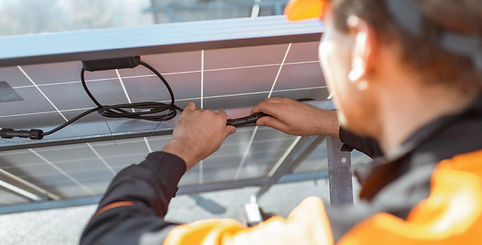 Technicien en train de faire de la maintenance et de connecter les câbles d'un panneau solaire