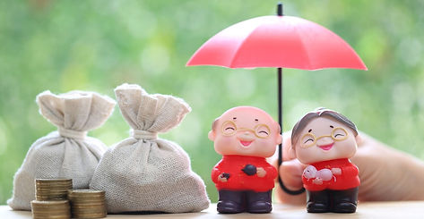 Deux figurines souriantes sous un parapluie rouge à côté de sacs de pièces de monnaie